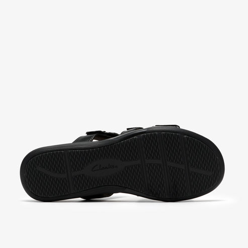 Black sandal showing the sole with a curved tread pattern.