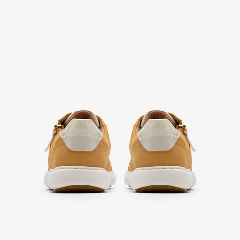 Rear view of tan sneakers with white soles and heel counters.