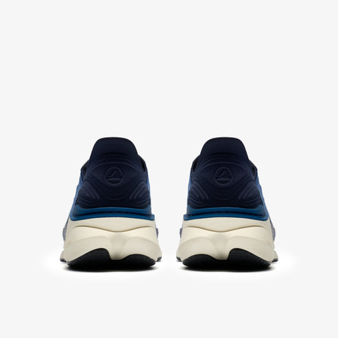 The back view of two navy and teal athletic shoes with white midsoles and black outsoles.