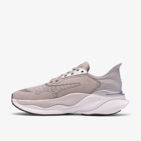 Side view of gray, low-top sneaker with a thick, white sole and a silver accent near the heel.