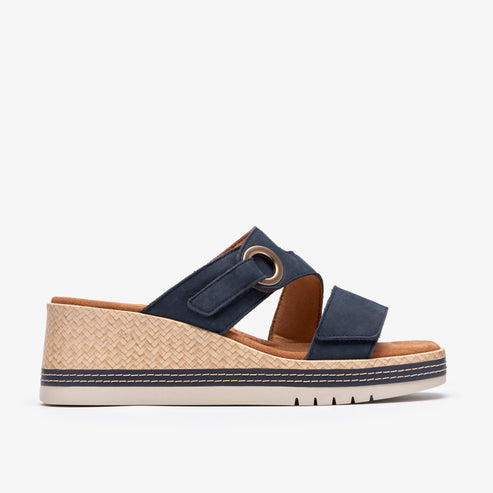 Navy wedge slide sandal with two straps, one with a metal grommet detail.
