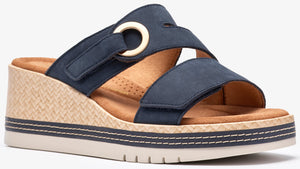 Navy wedge sandal with adjustable straps and decorative gold ring.