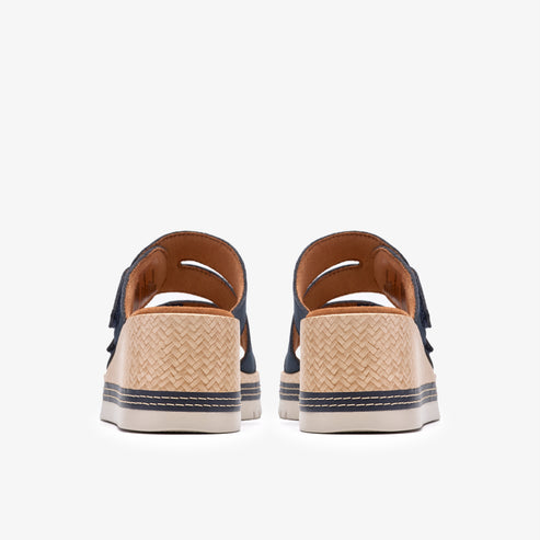 Rear view of two open-toed sandals with woven straw platform soles and dark-colored adjustable straps.