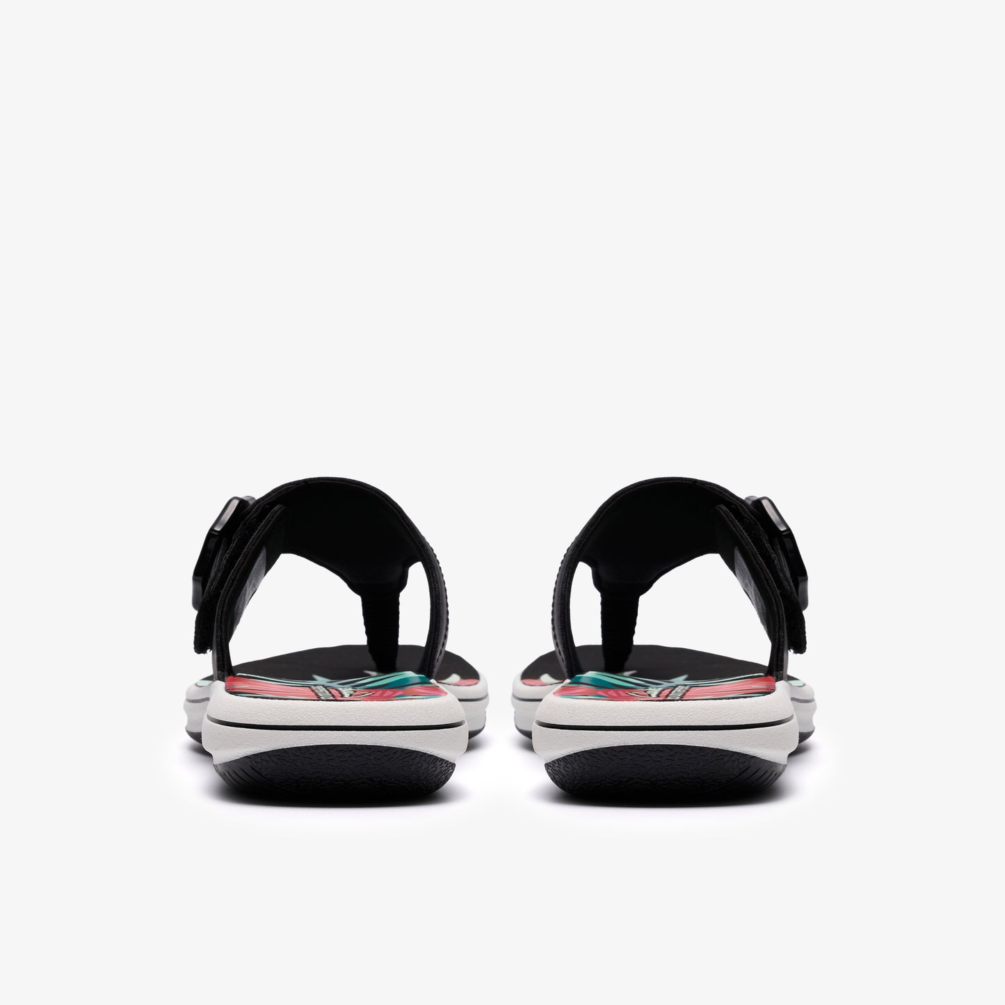 Two black sandals with floral designs, seen from behind.