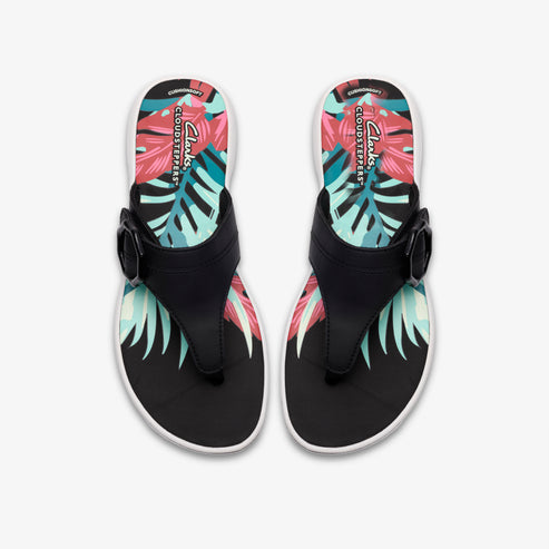 Overhead view of two black thong sandals with a buckle detail and a colorful tropical leaf design on the insole.