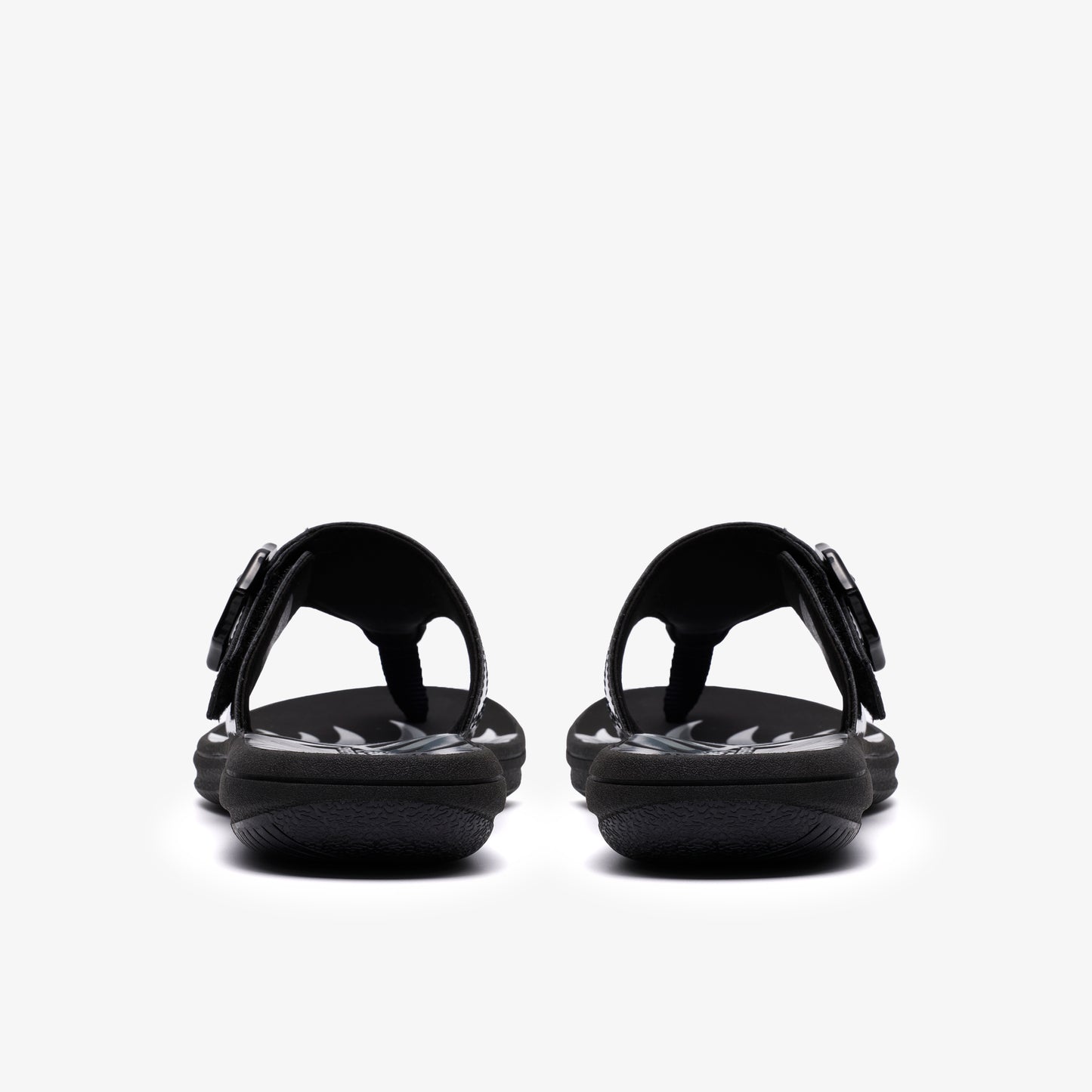 Pair of black flip-flops with adjustable straps seen from the back.