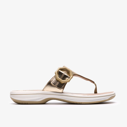 Gold sandal with round buckle.