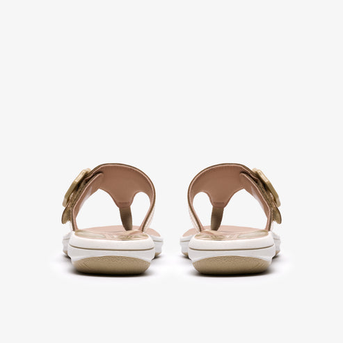 Pair of women's thong sandals, gold straps, flower buckle, white platform.