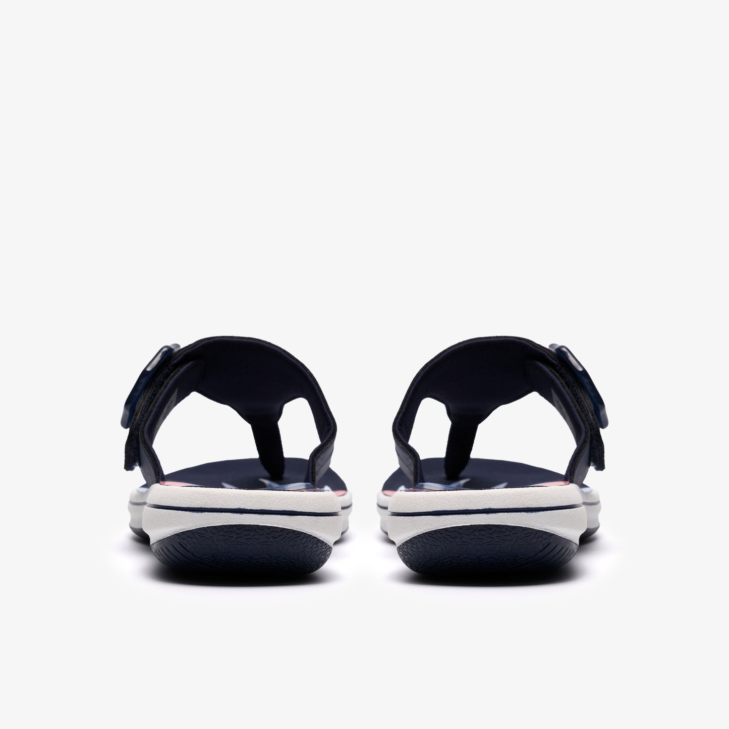 Pair of navy and white sandals with toe posts, viewed from the back.