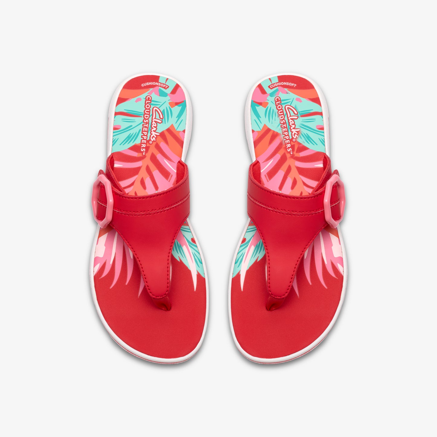 Pair of red flip-flops with colorful palm leaf print on insole and straps with decorative buckles.