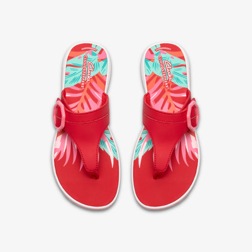 Pair of red flip-flops with colorful palm leaf print on insole and straps with decorative buckles.