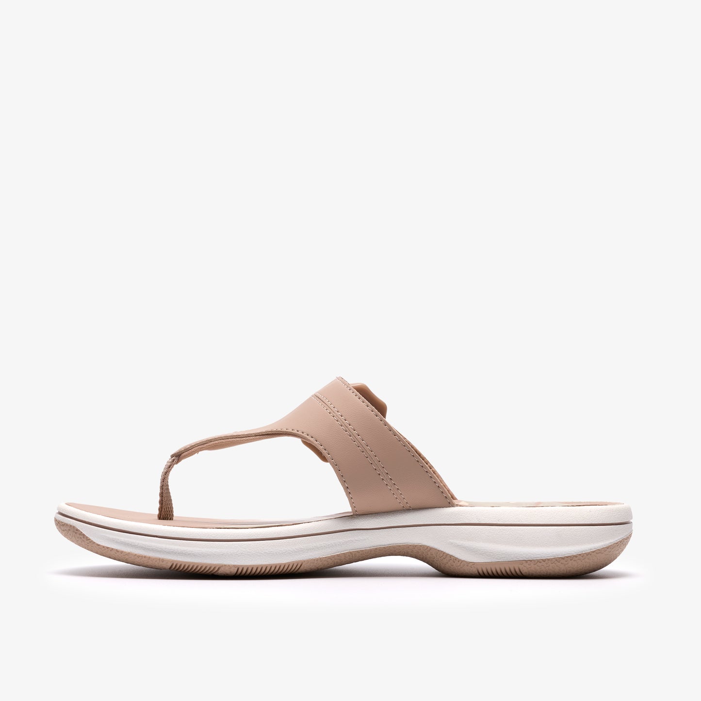 Side view of a beige sandal thong with a flat sole.