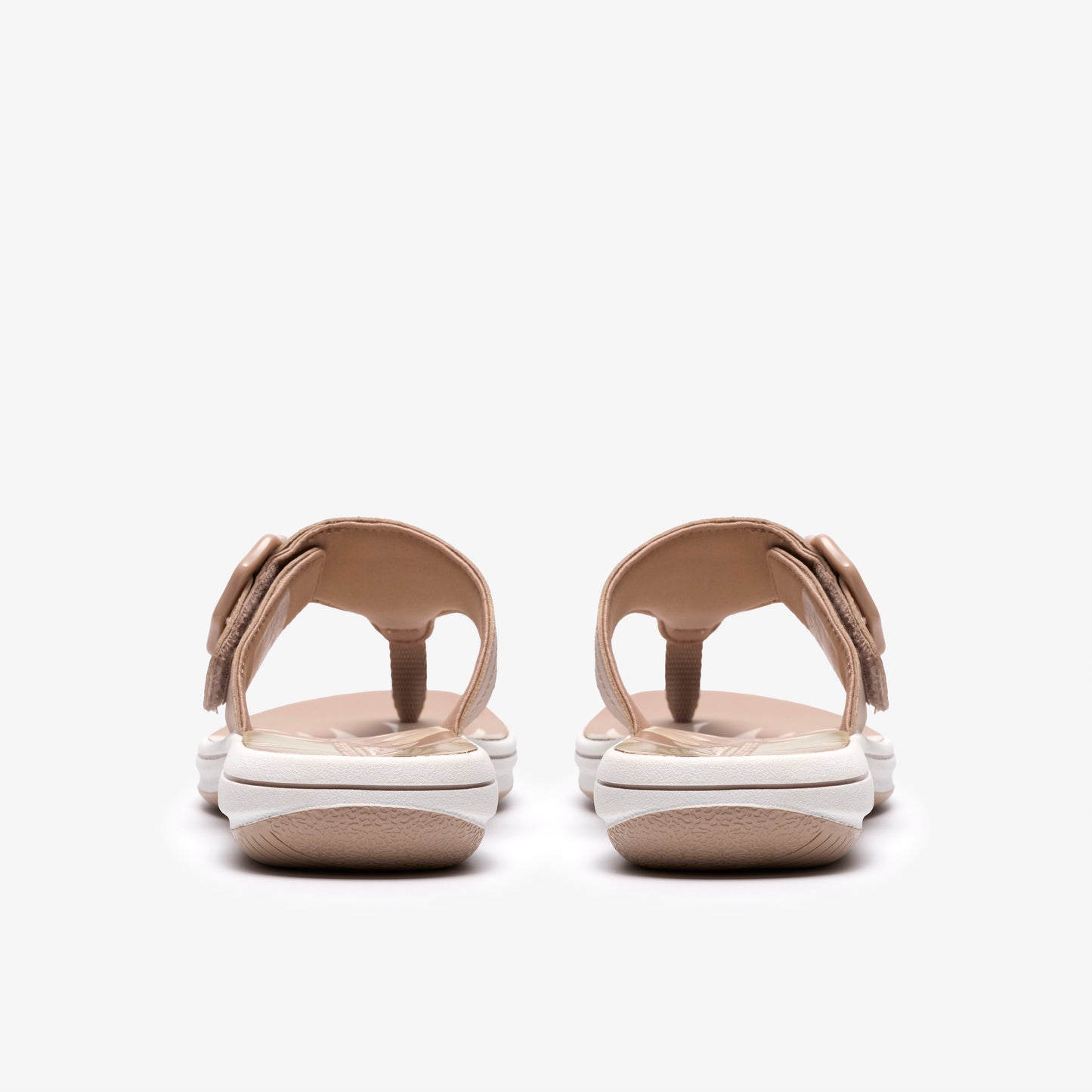 Tan sandals with adjustable Velcro straps and white soles, seen from the back.