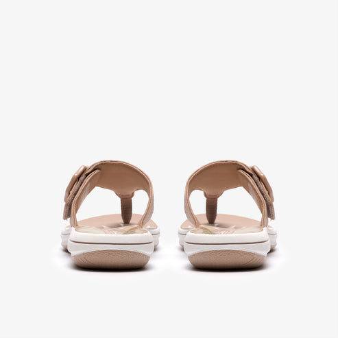 Tan sandals with adjustable Velcro straps and white soles, seen from the back.
