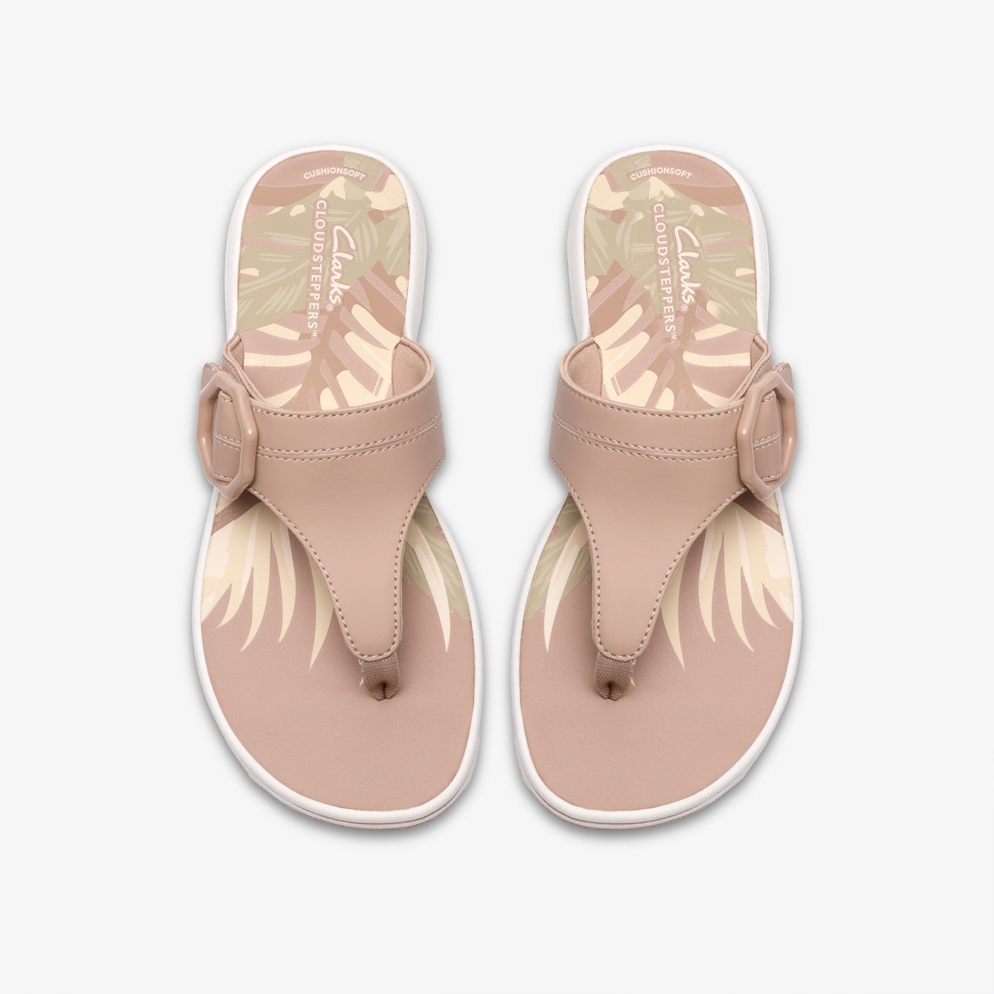 Pair of thong sandals with a buckle, blush pink straps and tropical leaf footbed.