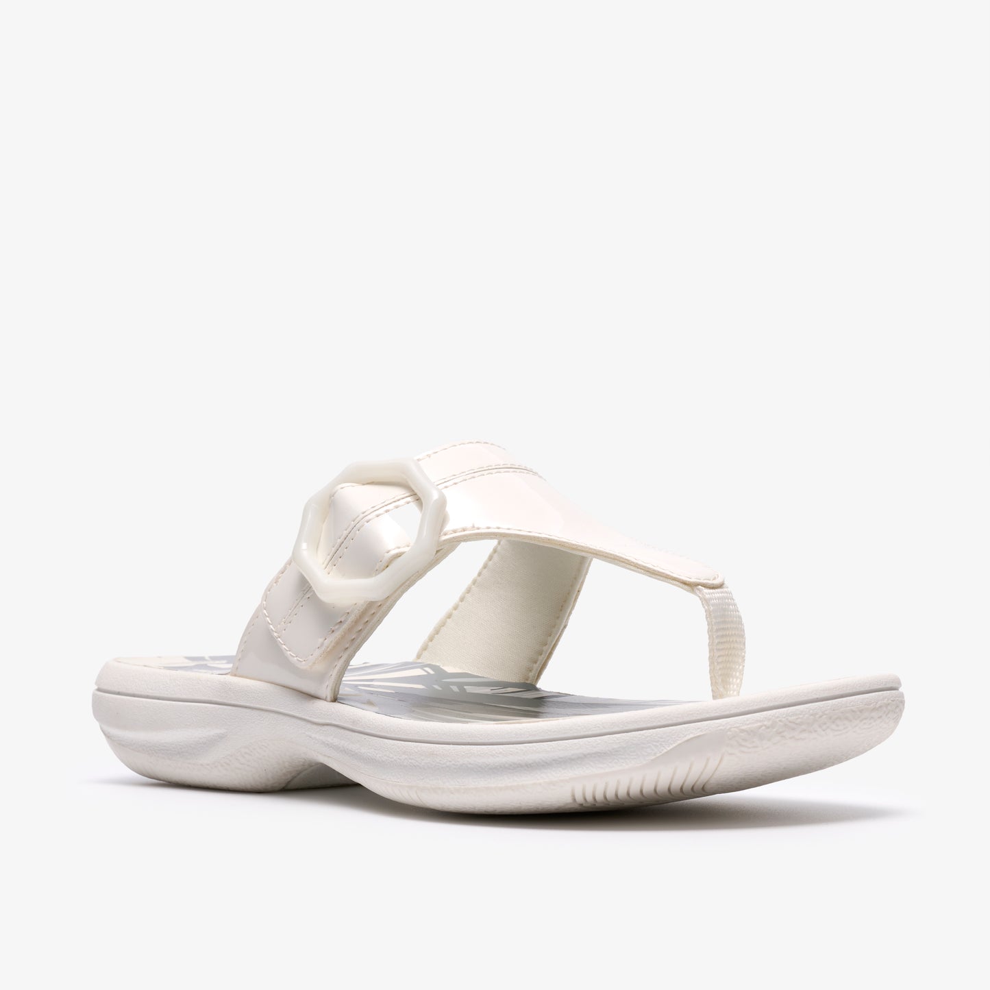 White sandal with toe post, strap over the foot, and a round buckle.