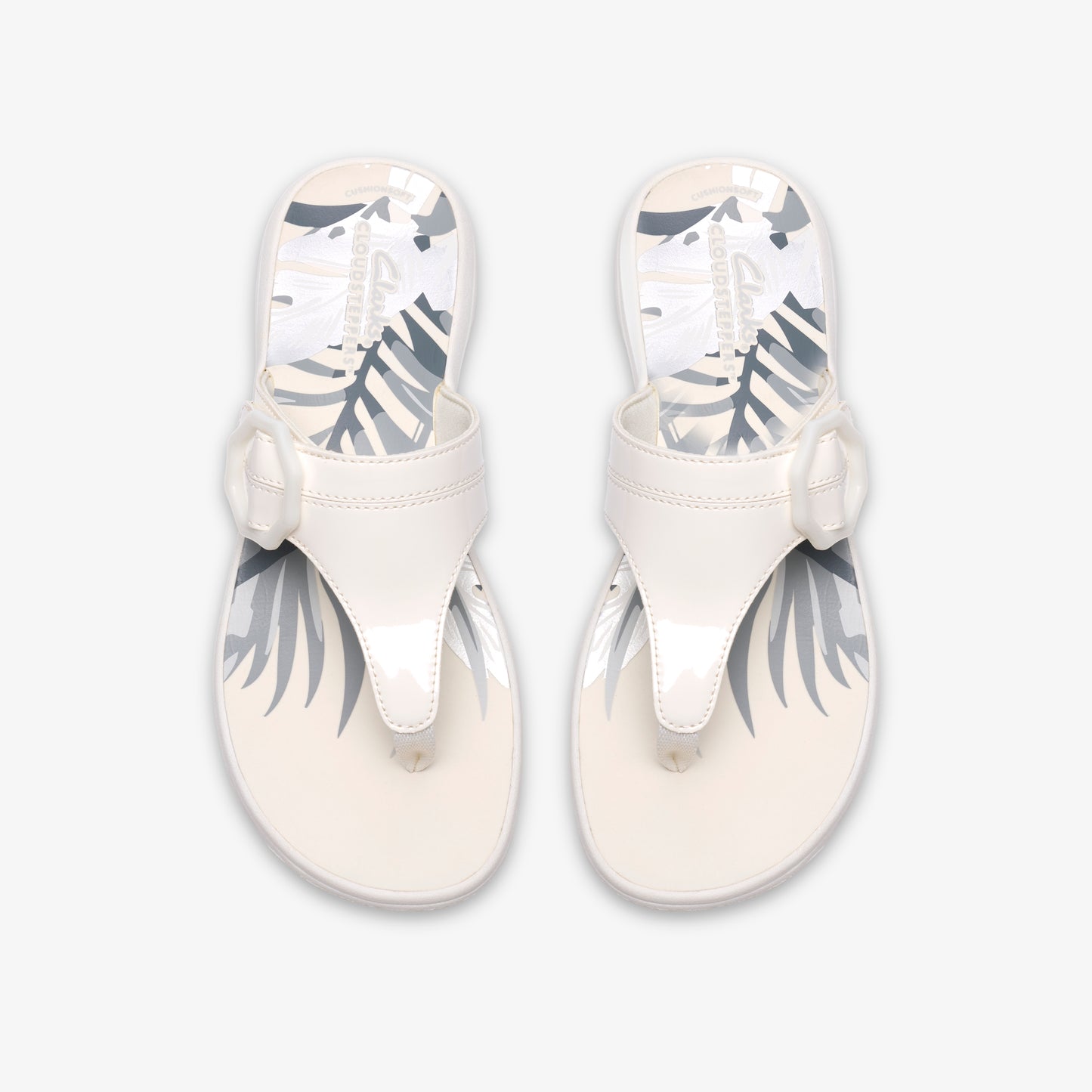 Pair of white patent leather thong sandals with decorative bow accent.