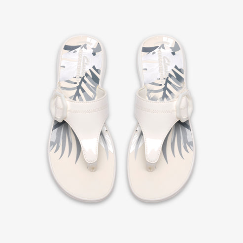 Pair of white patent leather thong sandals with decorative bow accent.