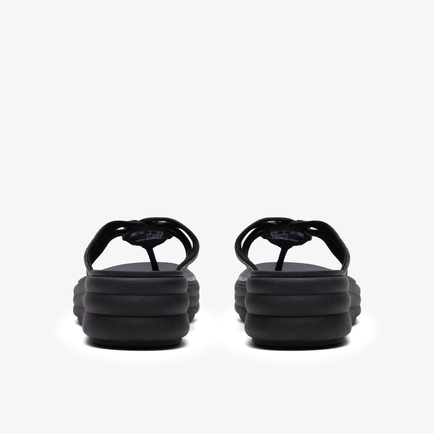 Elevated, black platform flip-flops with a thong strap; rear view.