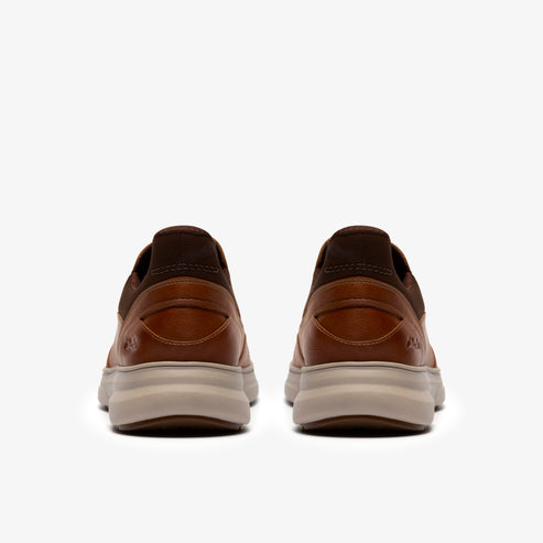 A pair of brown leather shoes with a beige sole, rear view.