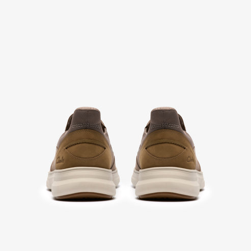 Two casual brown shoes, viewed from behind, displaying their thick, light-colored soles.