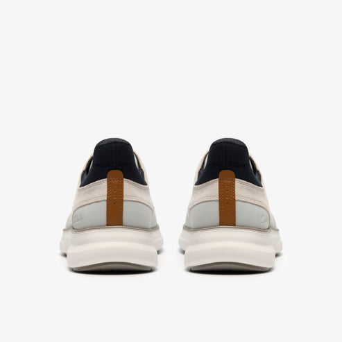 Pair of sneakers, rear view, with white and tan upper and thick white sole.
