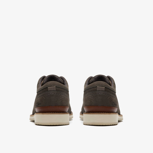 Pair of grey suede shoes with brown accent and white soles, viewed from the back.