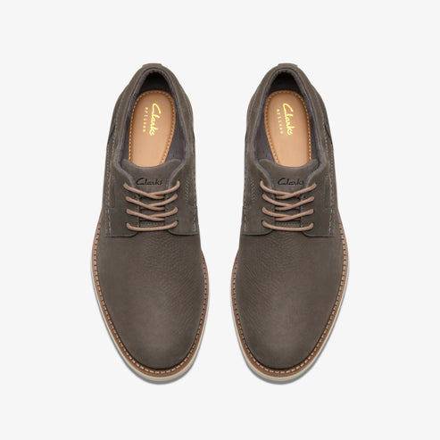 Top-down view of gray leather dress shoes with matching laces, visible insole text "Clarks ARTISAN".