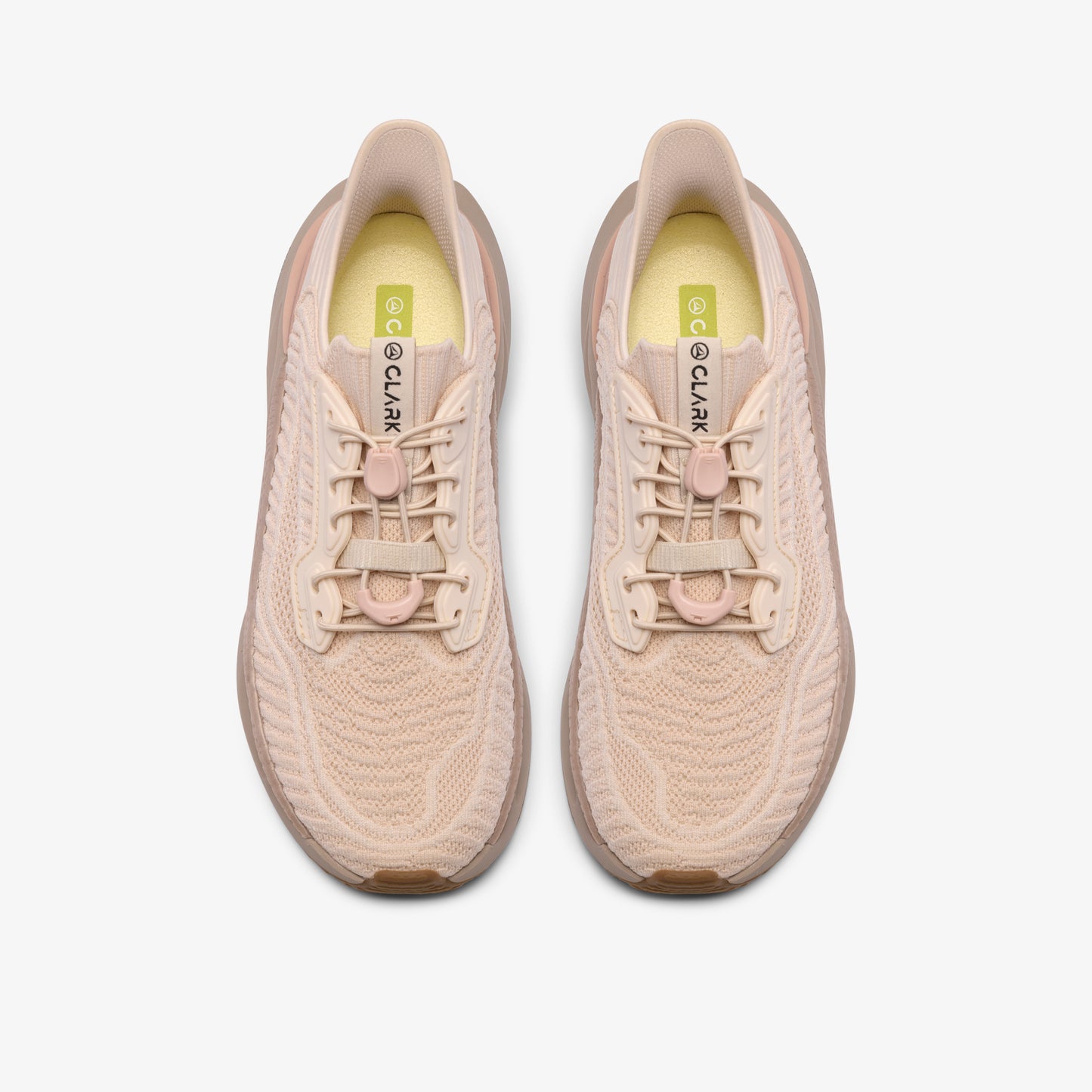 A pair of running shoes, top view, light beige color, with laces and a visible CLARK logo inside.