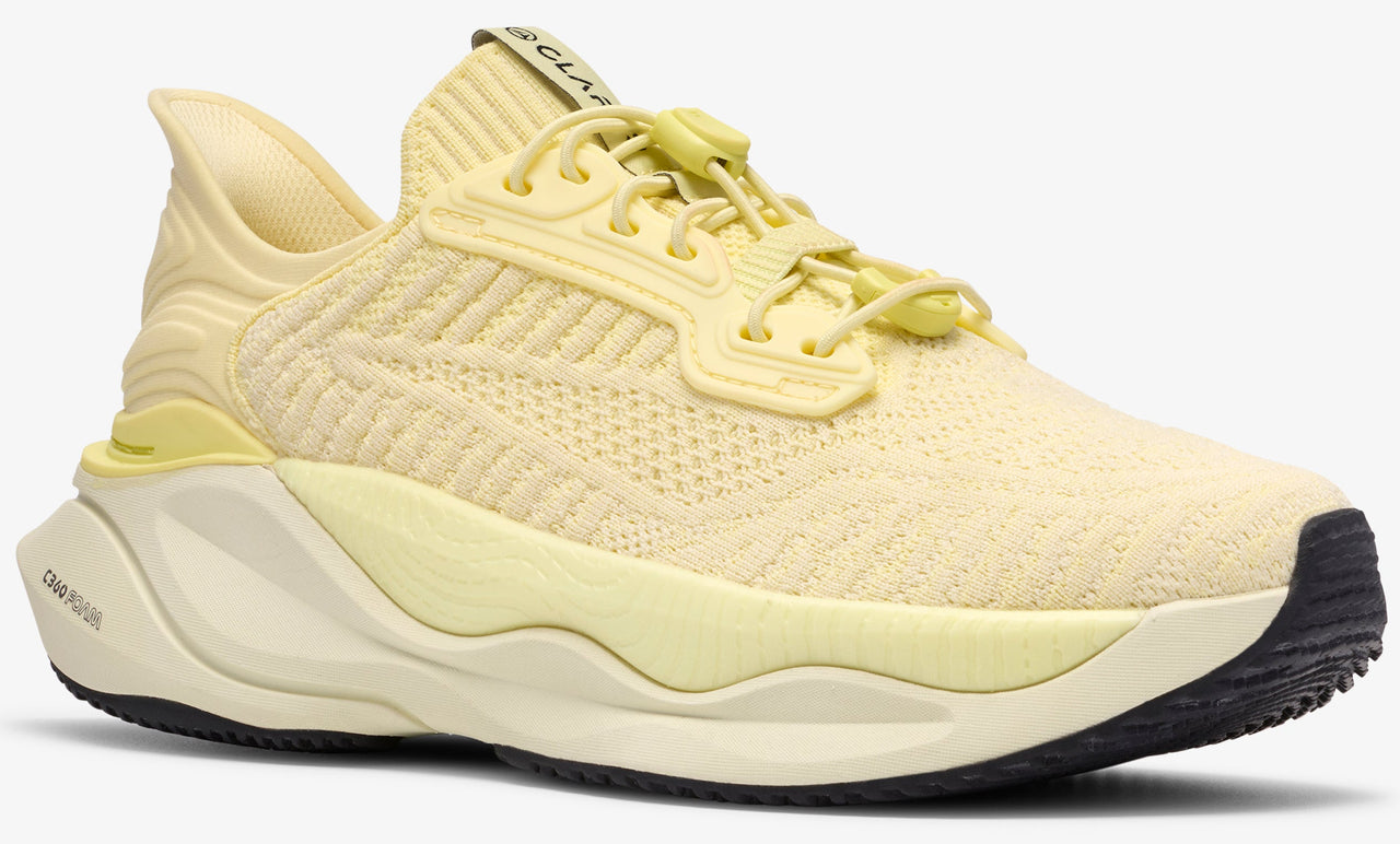 A yellow athletic shoe with a toggle lacing system and visible "CLAP" text on the tongue.
