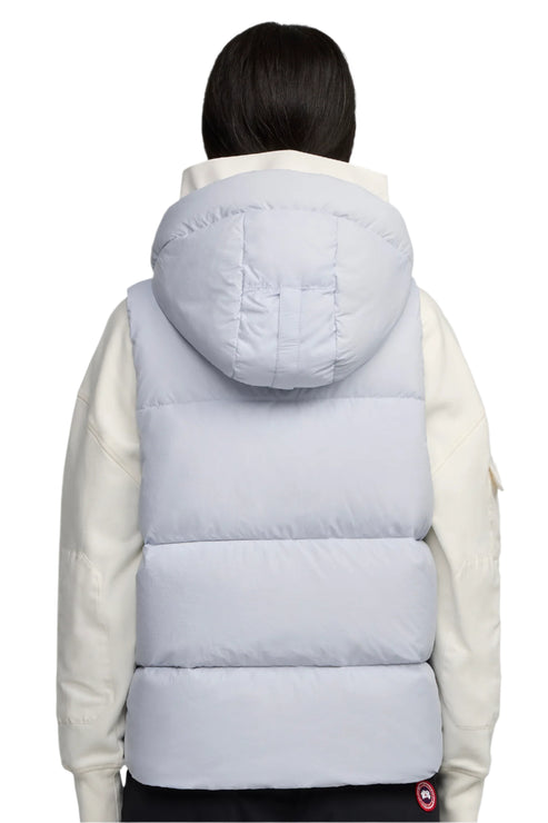Light blue hooded puffer vest with black trim around the bottom. Worn over a white jacket.