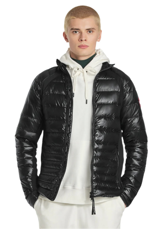 A man in a shiny black puffer jacket over a white hoodie.