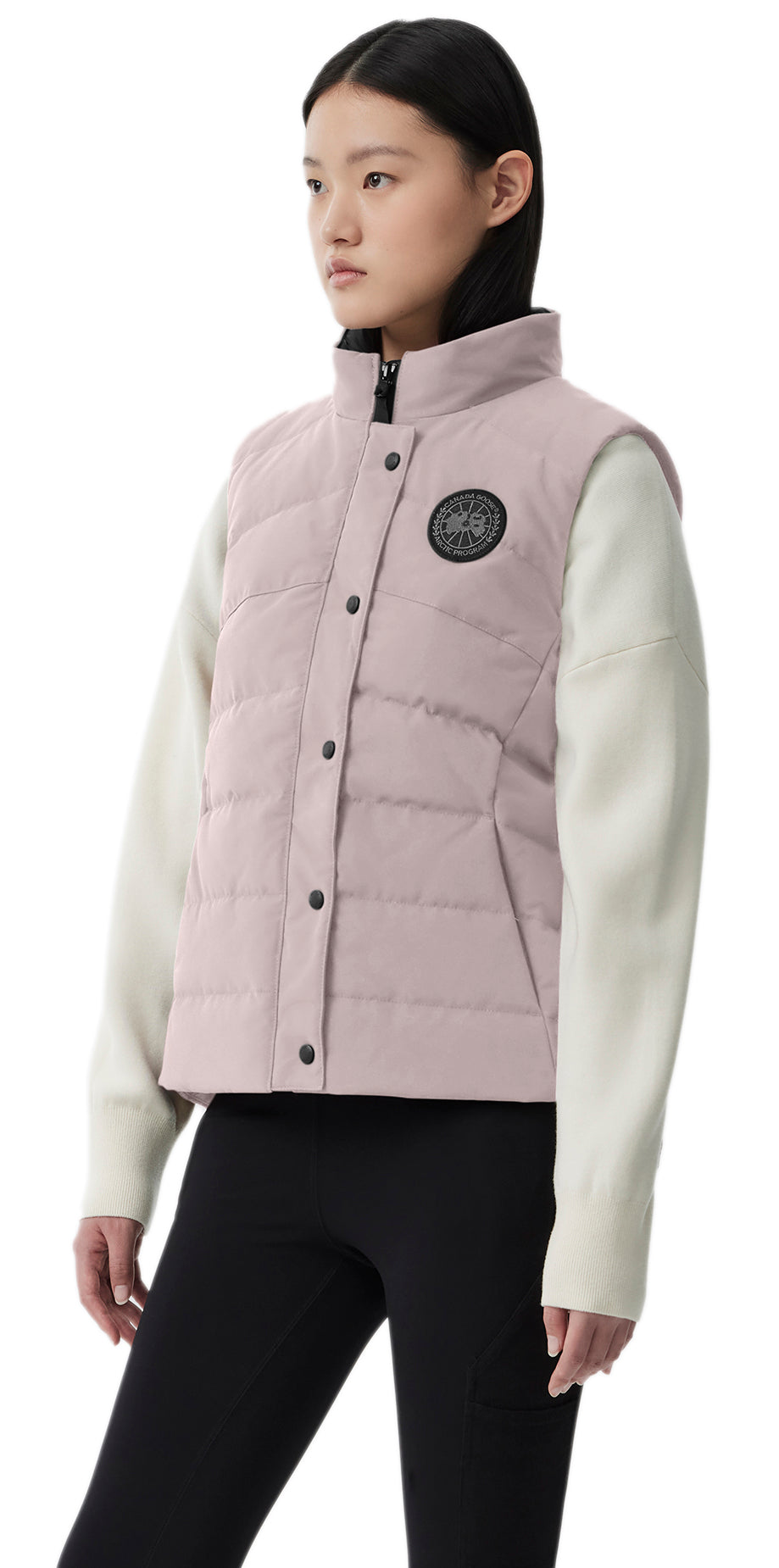 A woman in a pink vest with black leggings and white sleeves.