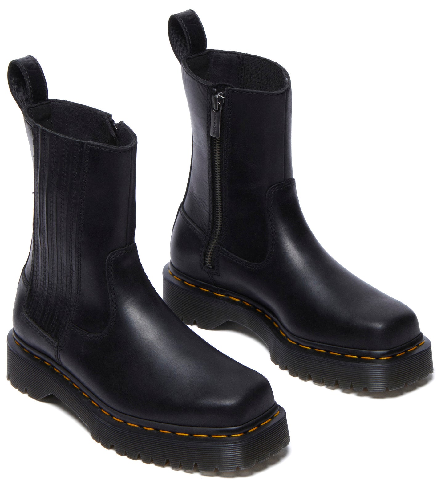 A pair of low-heeled black boots with yellow stitching and a side zipper.