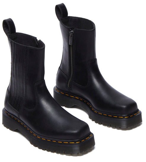A pair of low-heeled black boots with yellow stitching and a side zipper.