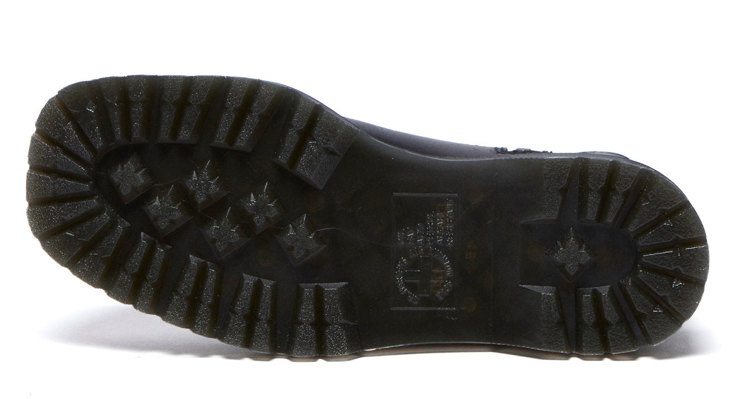 Close-up of the dark textured lug sole of a boot with stars and the Dr. Martens logo visible.