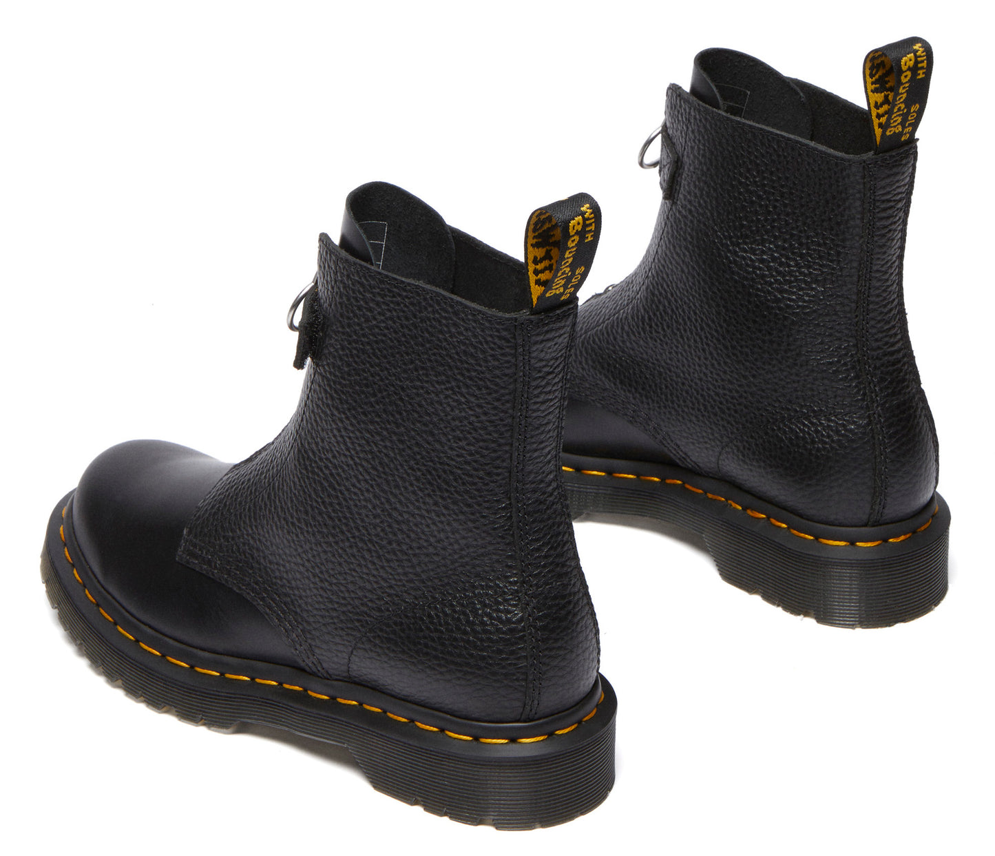 Two textured black leather ankle boots with yellow stitching on black soles, back view, pull tabs