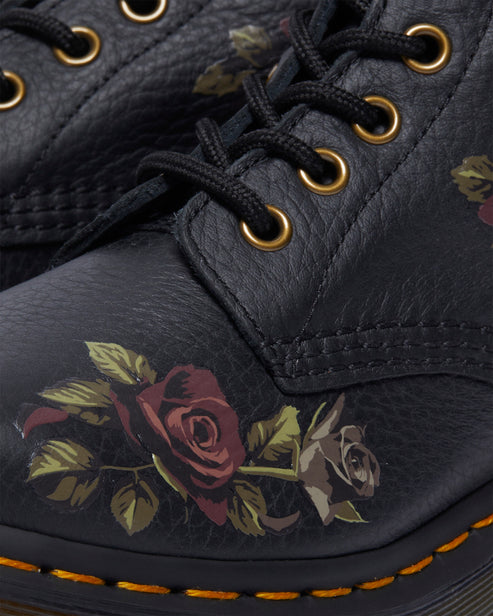 Close-up of black leather boot with floral rose design and black laces.