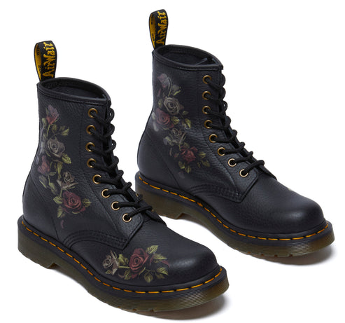 Pair of black ankle boots with rose floral print and yellow stitching.