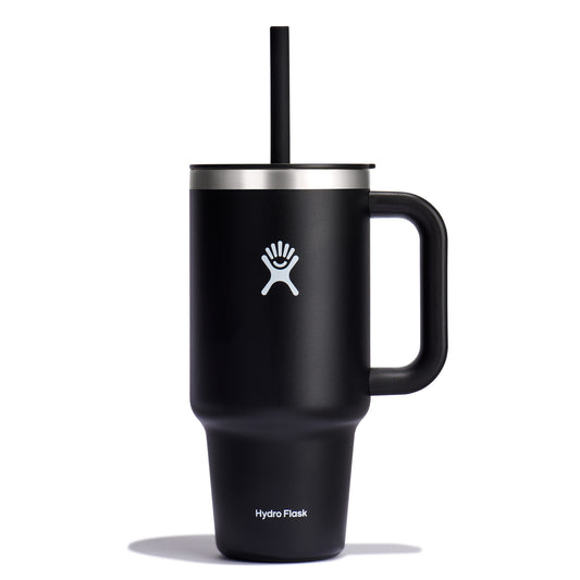 Black insulated mug with handle and straw, with a white logo of a person near a palm tree, and the words "Hydro Flask" near the bottom.
