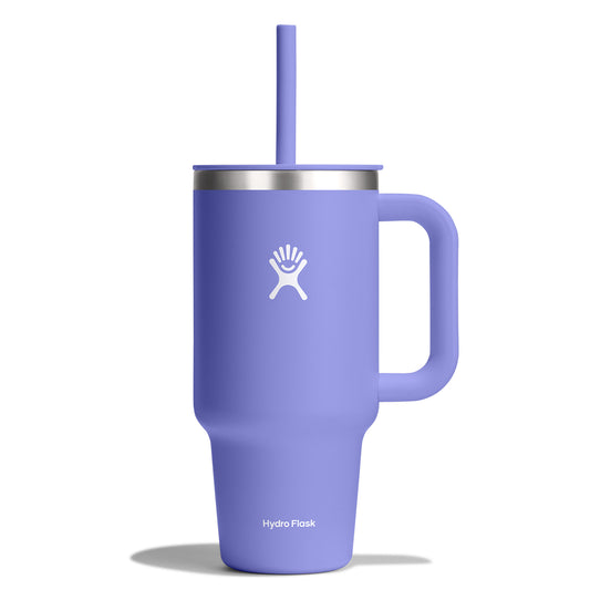 A periwinkle blue stainless steel mug with a handle, a straw, and a white logo of a stylized figure on the side.