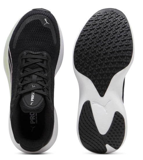 Pair of black sneakers; one shows the top with laces, the other shows a grippy white and black sole and a white logo.