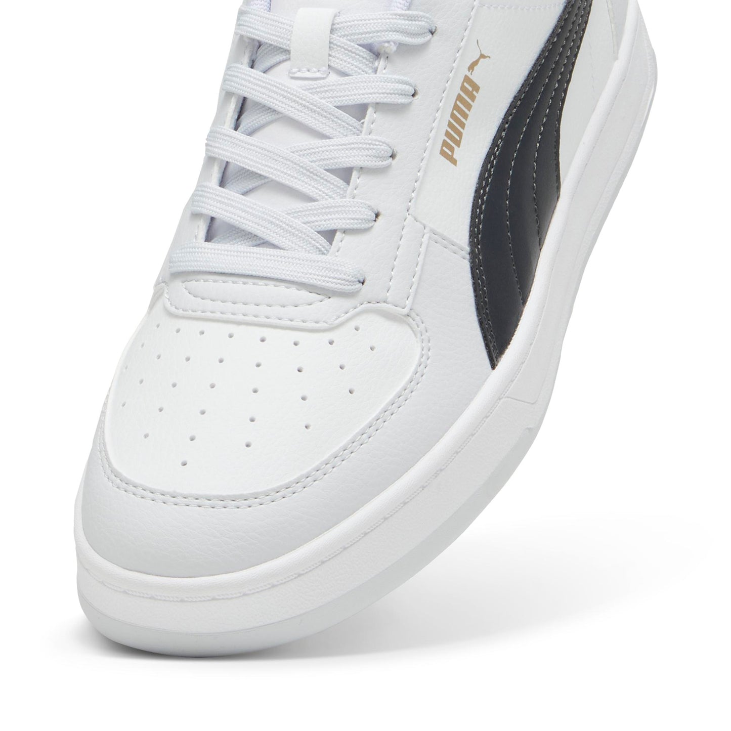 Close-up of a white shoe with white laces and a black stripe. "Puma" is printed in gold.