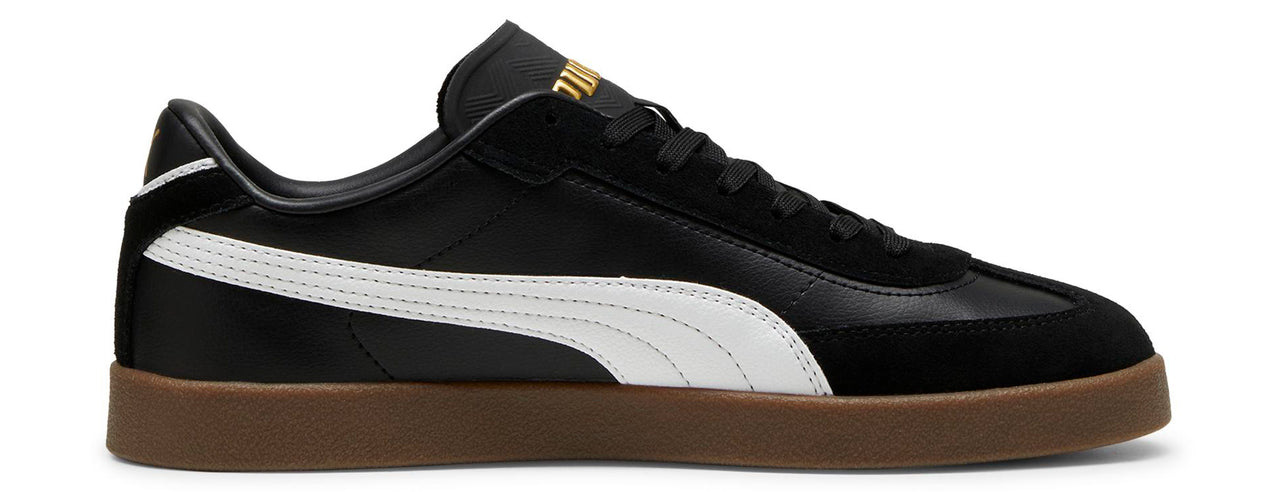A black sneaker with a white stripe and a brown sole.