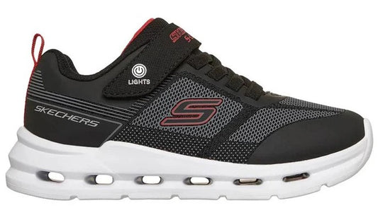 Black and grey sneaker with an S logo on the side, white sole with oblong cutouts, and velcro strap.