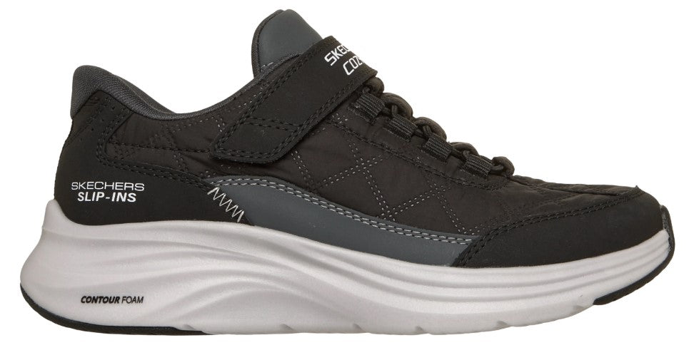 Side view of a gray slip-on sneaker with a thick white sole, elastic laces and "SKECHERS SLIP-INS" printed on the side.