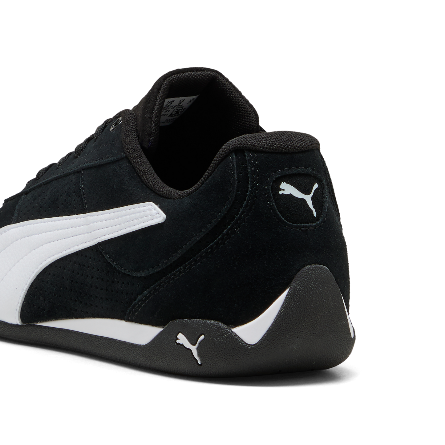 Close-up of a black sneaker with a white stripe, Puma logo on heel, and low profile sole.
