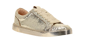 A gold-toned slip-on sneaker with a metallic textured surface.