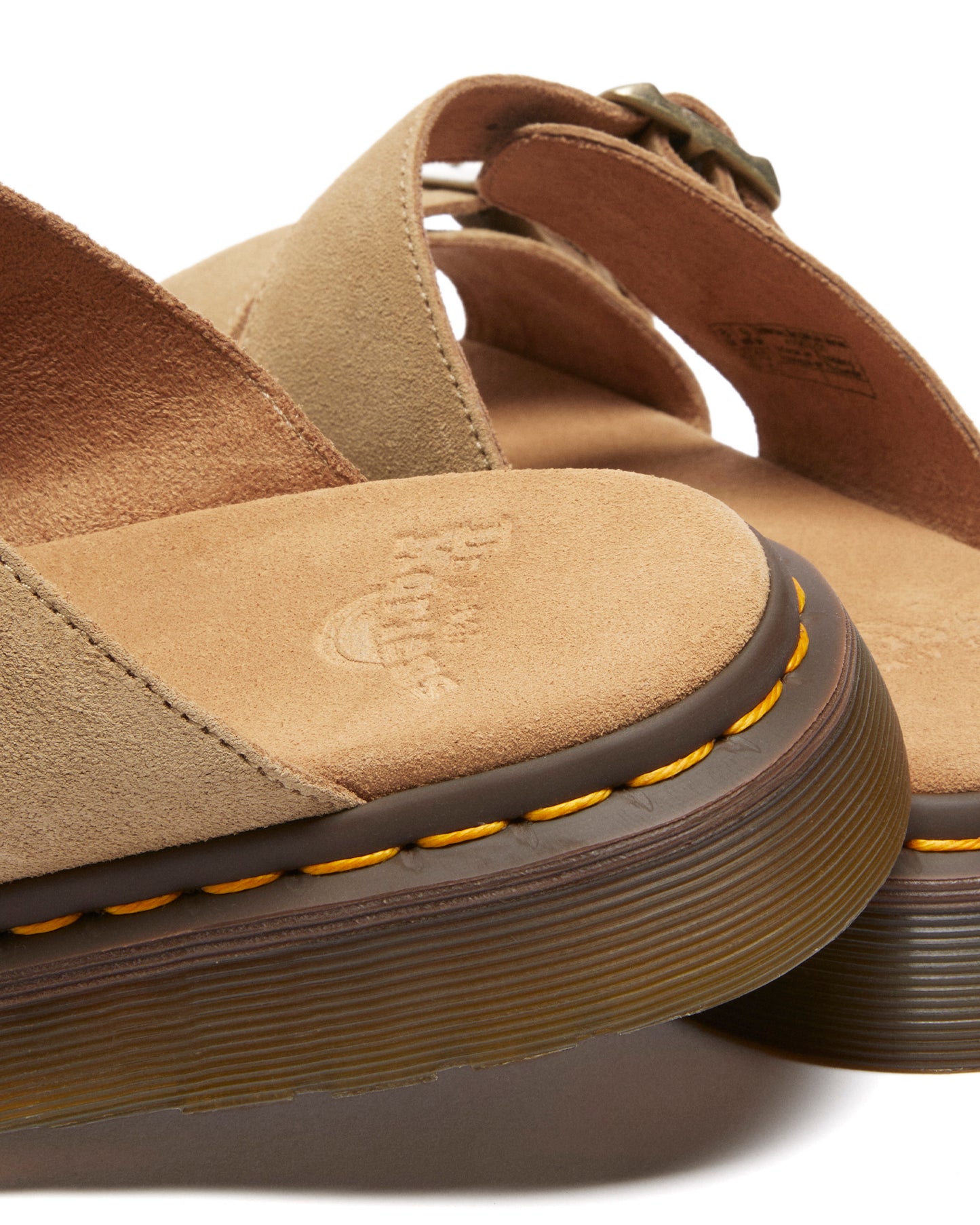 Sandals with tan straps and yellow stitching.