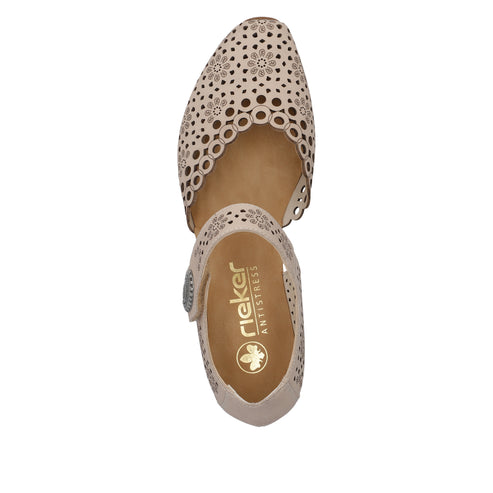 Beige flat shoe with floral laser cut pattern, Rieker Antistress logo and silver button.
